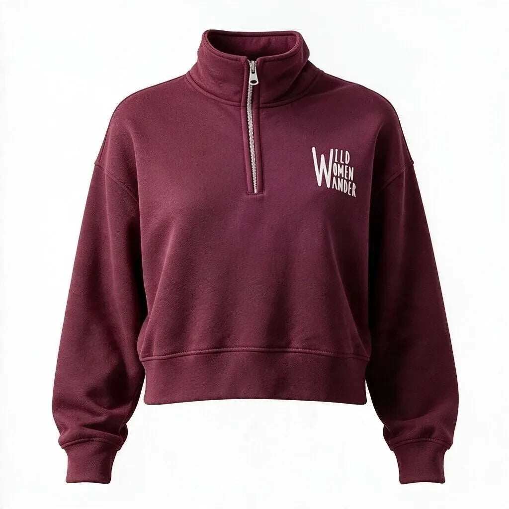 Wild Women Wander burgundy cropped quarter-zip sweatshirt with white logo embroidery on the chest.