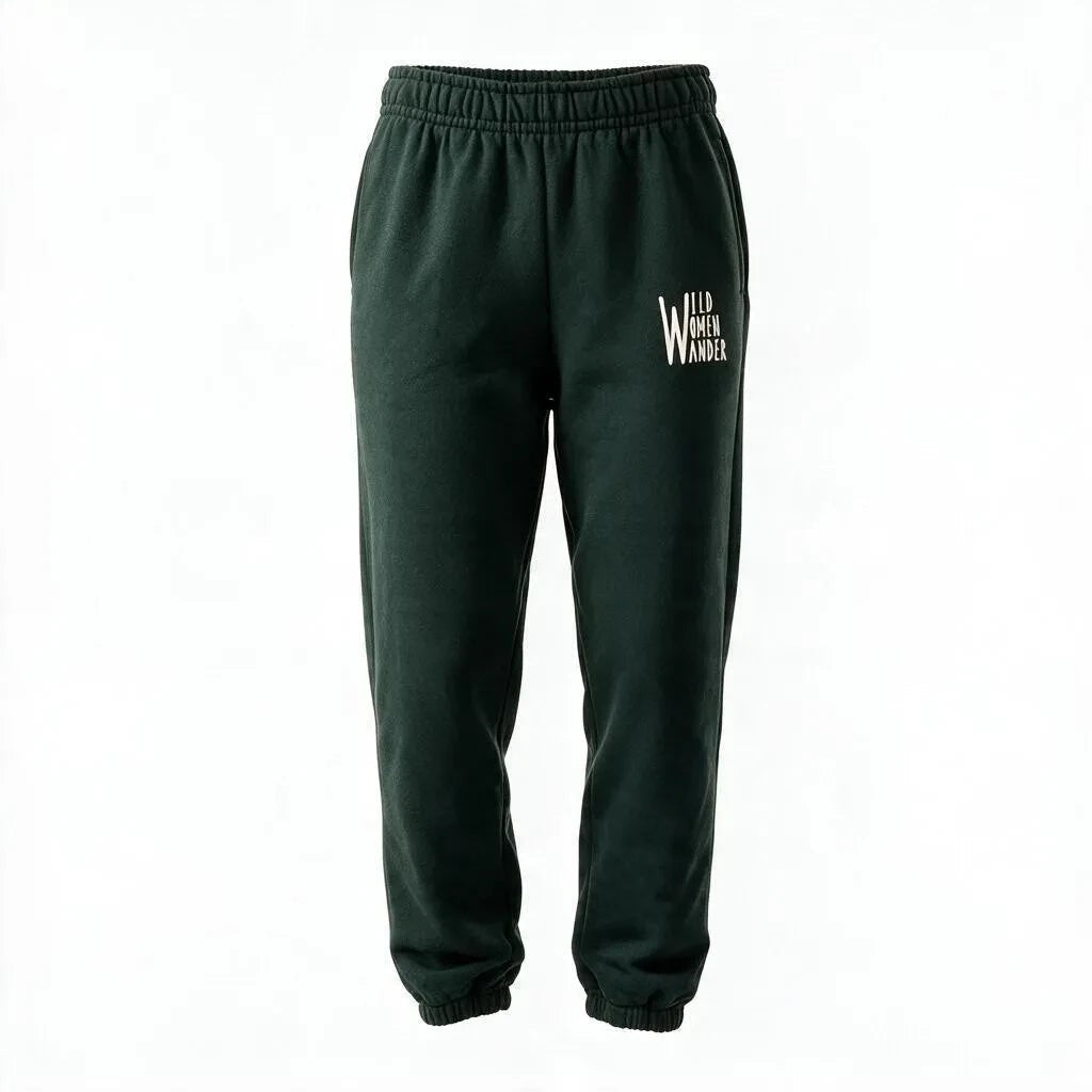 Wild Women Wander dark green relaxed-fit joggers with elastic cuffs and white adventure-themed logo on the hip.